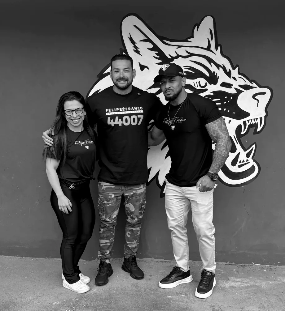 Felipe Franco com a equipe da Lobus Gym, em frente ao grafite do lobo na fachada da academia